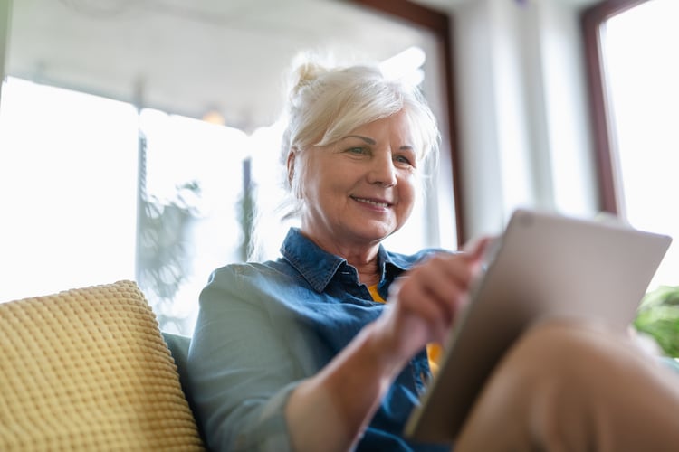 Senior lady living at home and scrolling on laptop