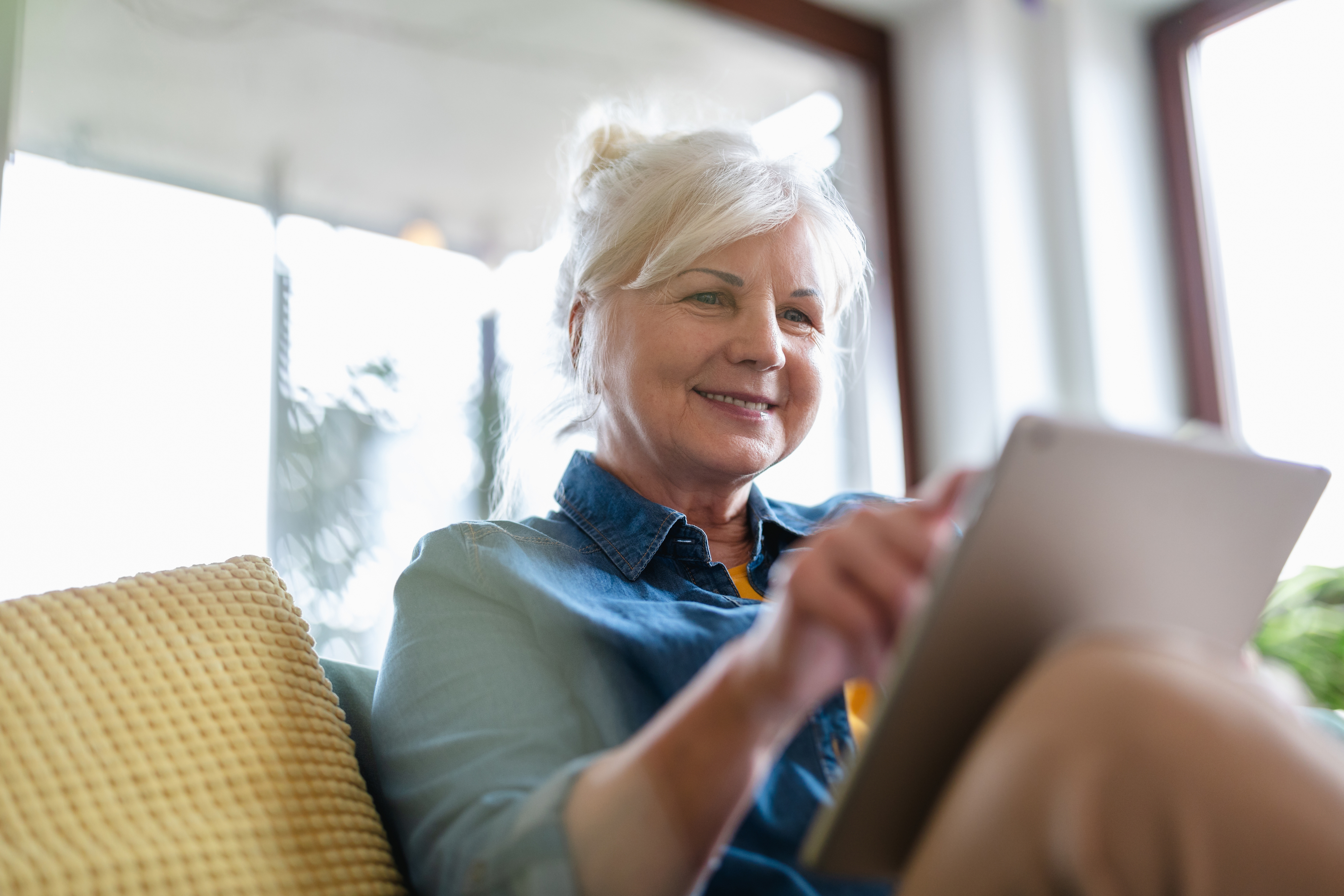 Senior lady living at home and scrolling on laptop